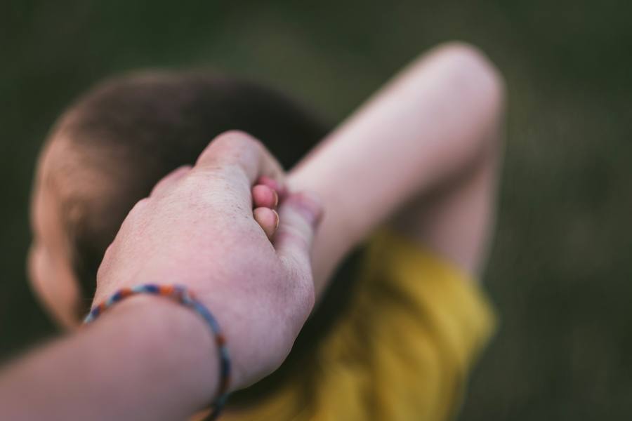 Caregiver holding child's hand